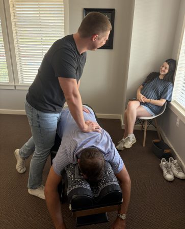 Dr. Cameron Williams performing a seated chiropractic adjustment