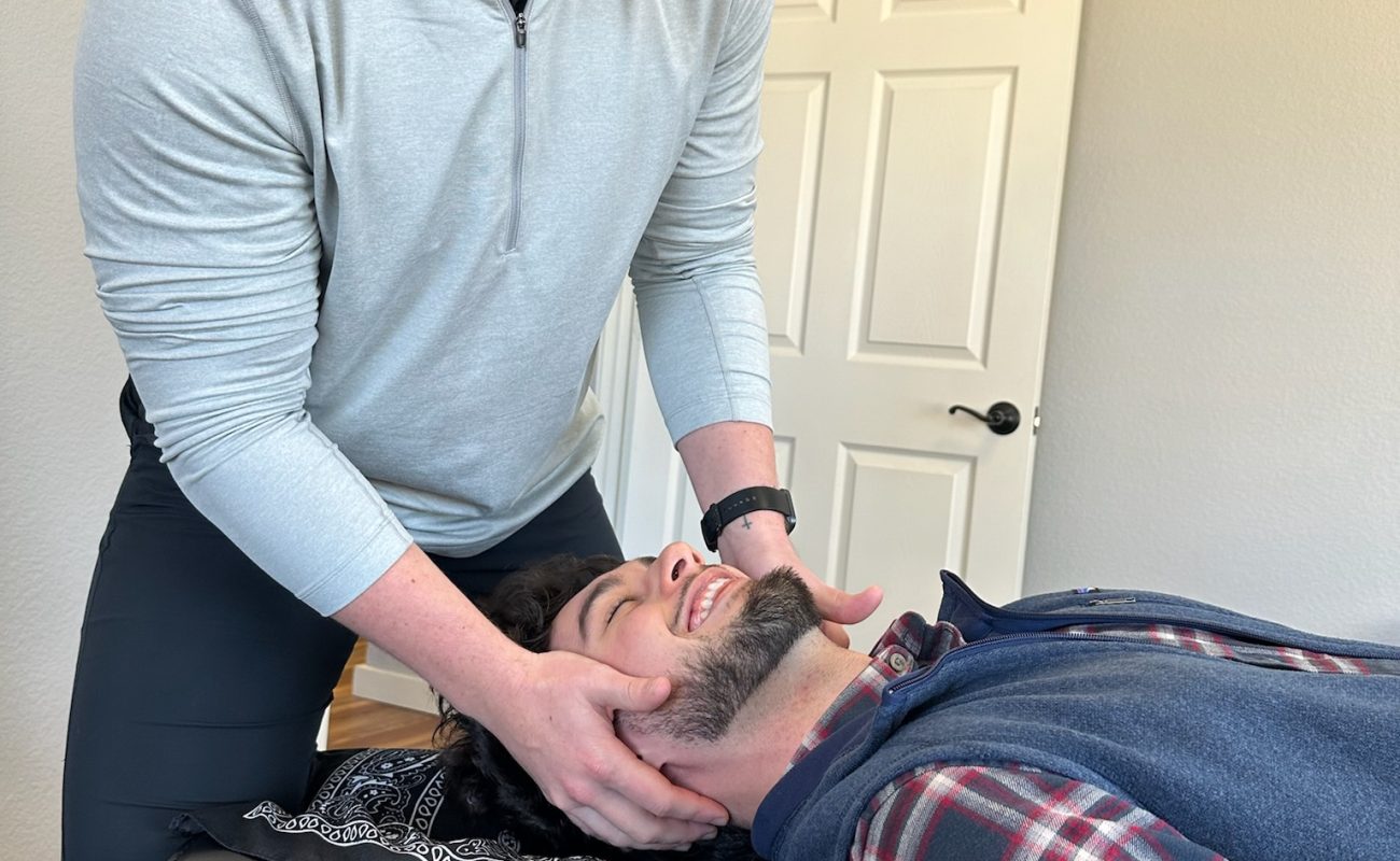 Dr. Cameron Williams performing a head adjustment, close-up view
