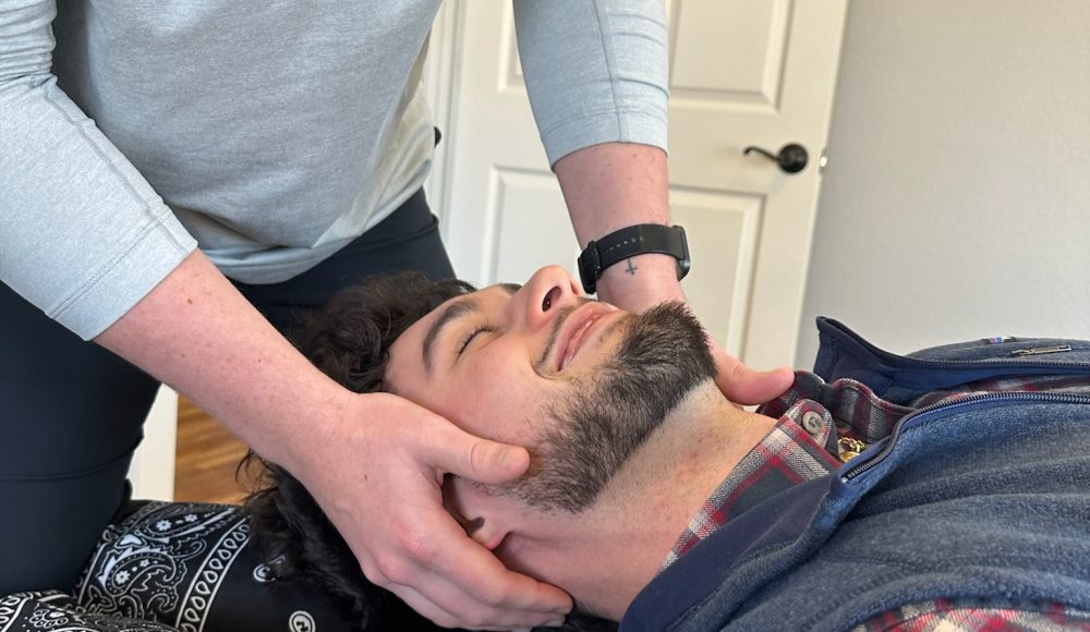 Dr. Cameron Williams performing a close-contact head adjustment on a patient