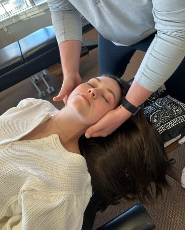 Close-up of a chiropractic adjustment performed on a patient's head and neck