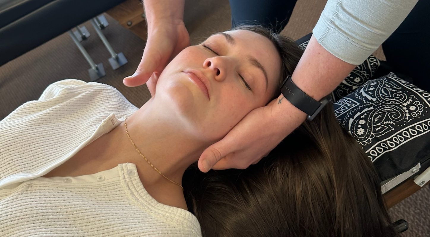 Close-up of a chiropractic adjustment performed on a patient's head and neck